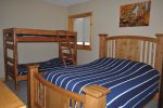 Eagle Trail Lodge bedroom with queen bed and bunk beds. 